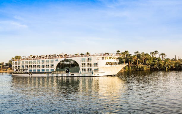 Cruise ship on the Nile River with palm trees in the background during a 4-day Nile cruise.