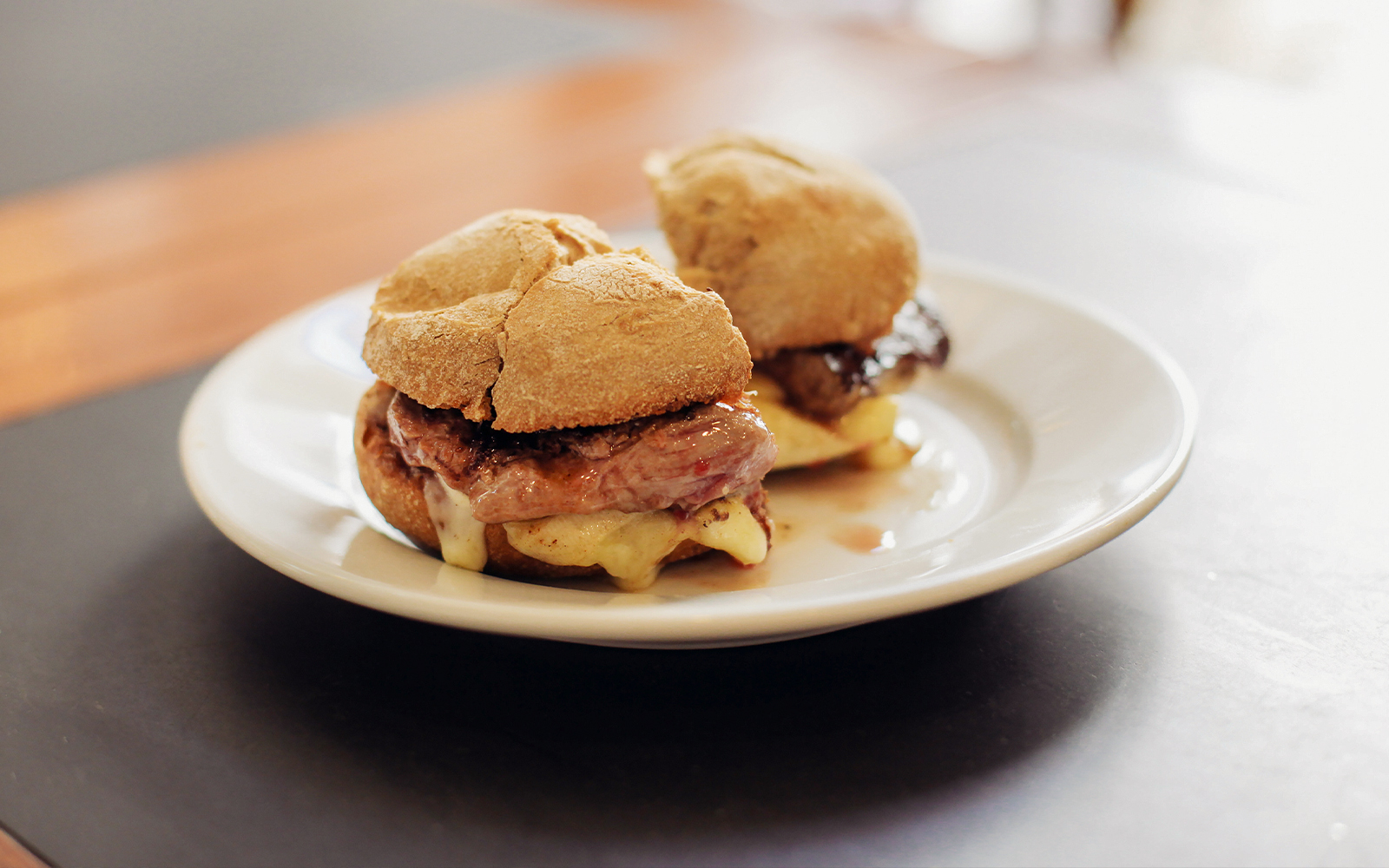 Portuguese prego sandwich with steak and mountain cheese on a plate.