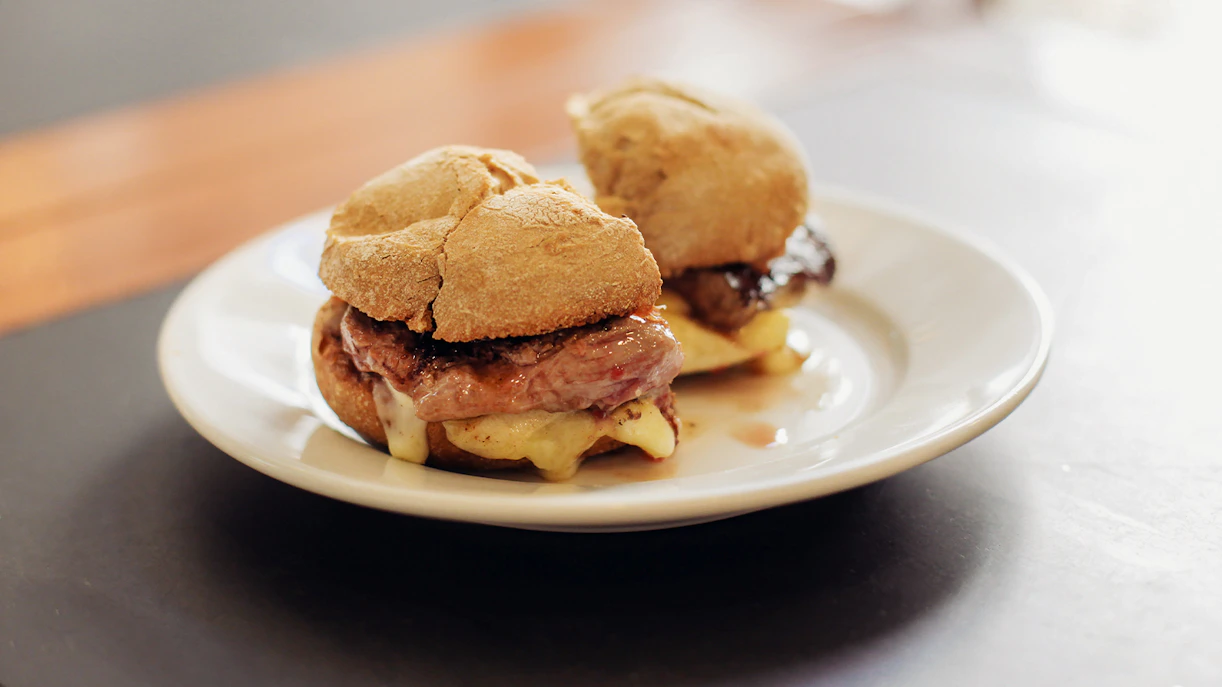 Portuguese prego sandwich with steak and mountain cheese on a plate.