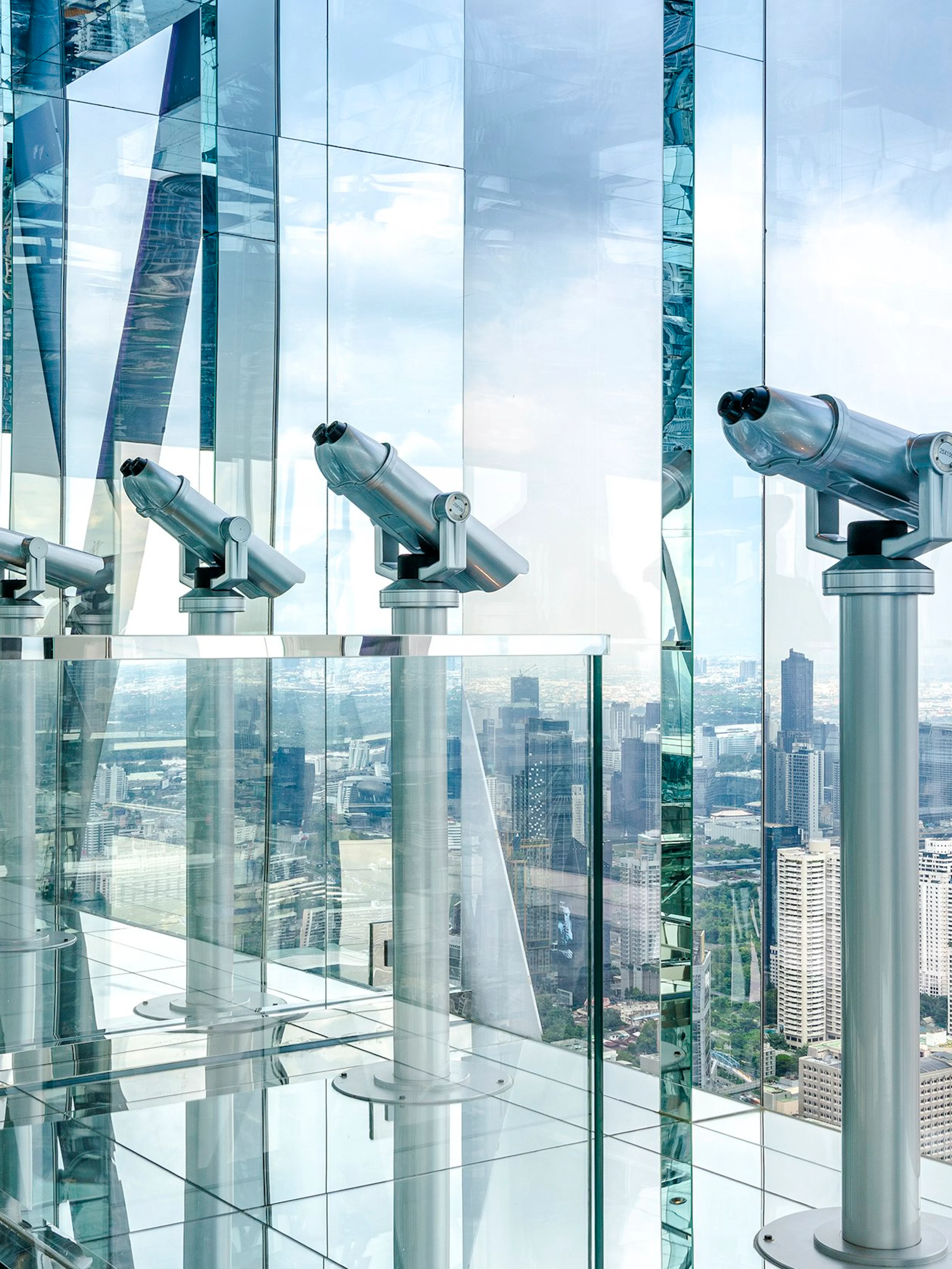 Telescopes on Akara Sky Hanuman observatory deck overlooking Bangkok skyline.