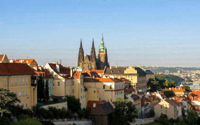 Prague Castle view with red-roofed buildings and Vltava River in the background.