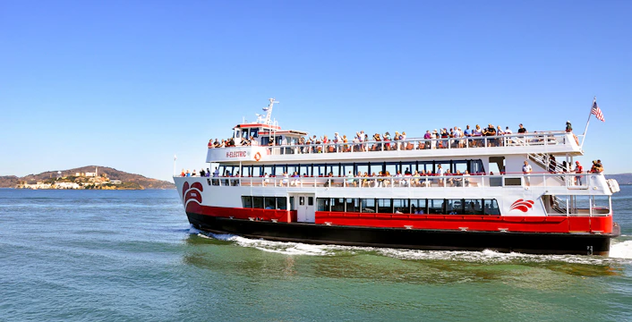 Cruise ship with passengers sailing near Alcatraz Island on San Francisco Bay, USA.