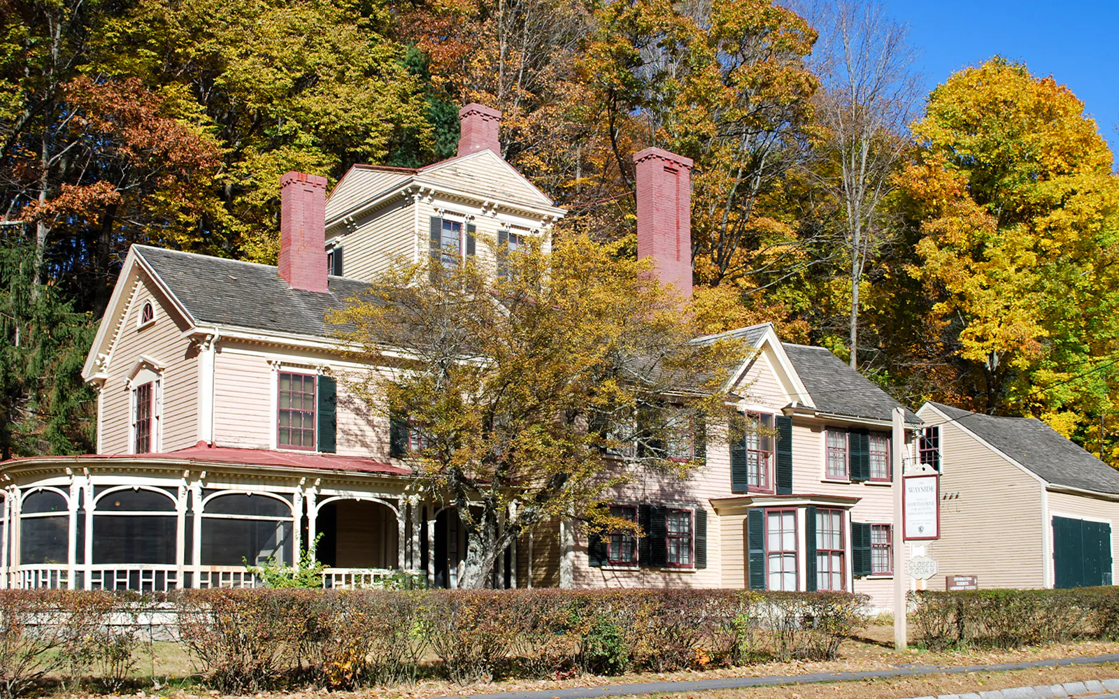 Wayside House in Boston surrounded by autumn trees.