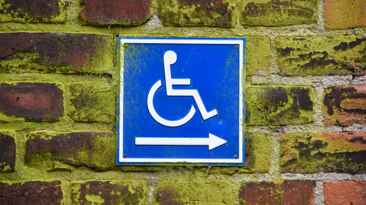 Wheelchair accessibility sign on a brick wall at Cinecitta Si Mostra.