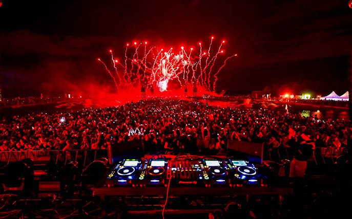 DJ console at Versailles Electro Concert with fireworks and crowd.