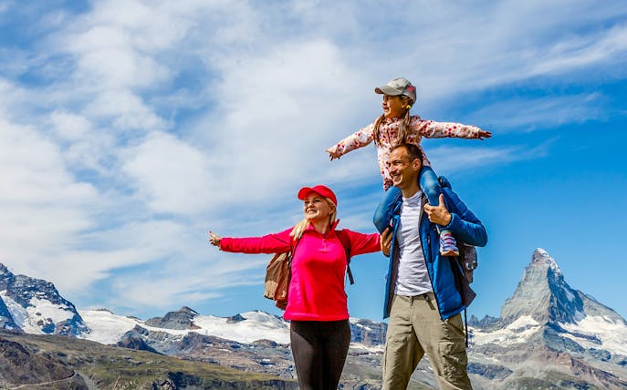 Family hiking on Mount Titlis with scenic mountain views.