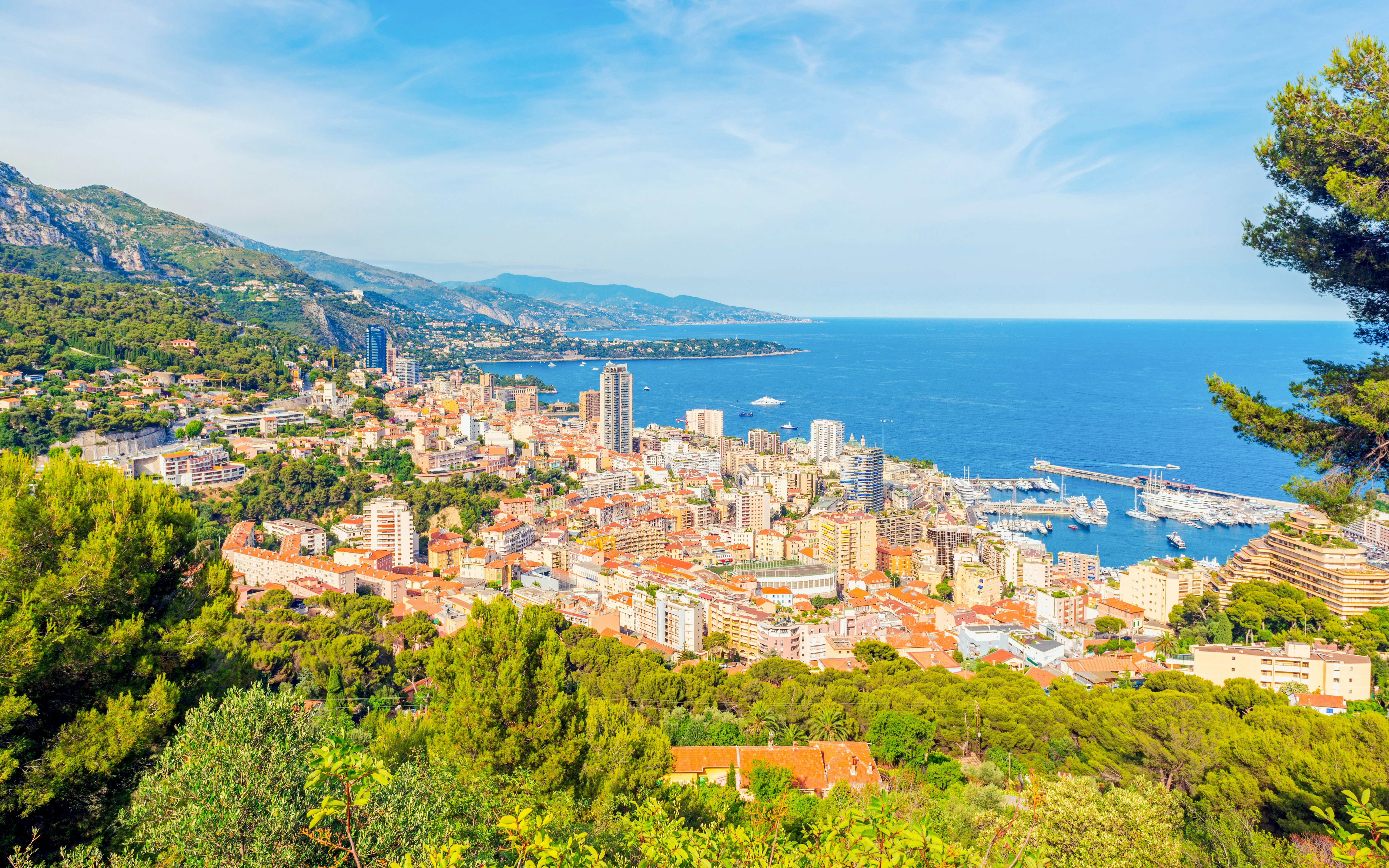 Aerial view of the French Riviera coastline with buildings and yachts in June.