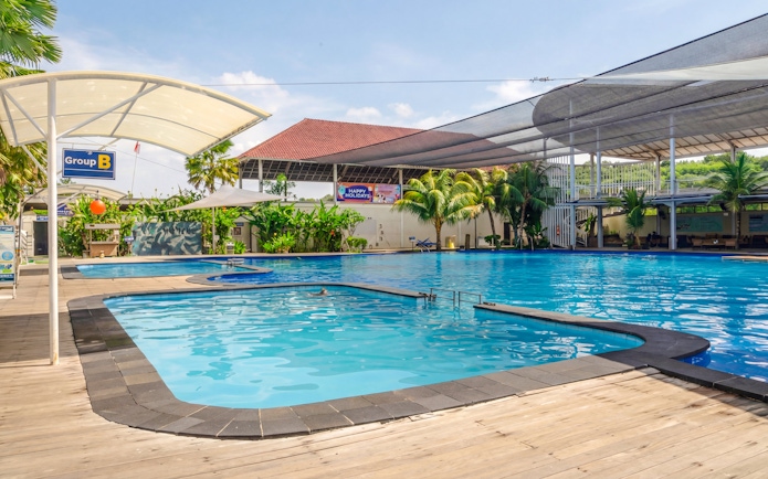 Outdoor pool area at Bali Exotic Marine Park with shaded seating and tropical plants.