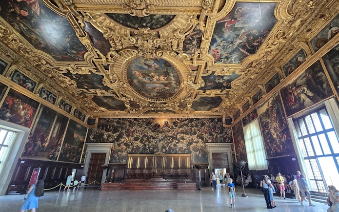Visitors exploring the ornate interior of the Doge's Palace in Venice.