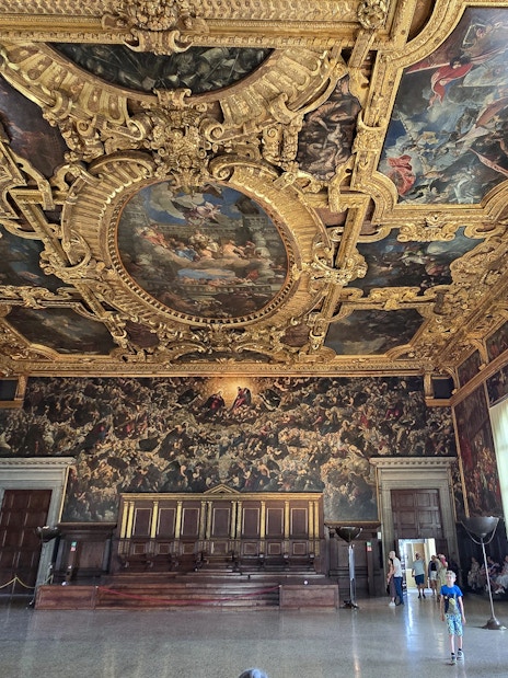 Visitors exploring the ornate interior of the Doge's Palace in Venice.