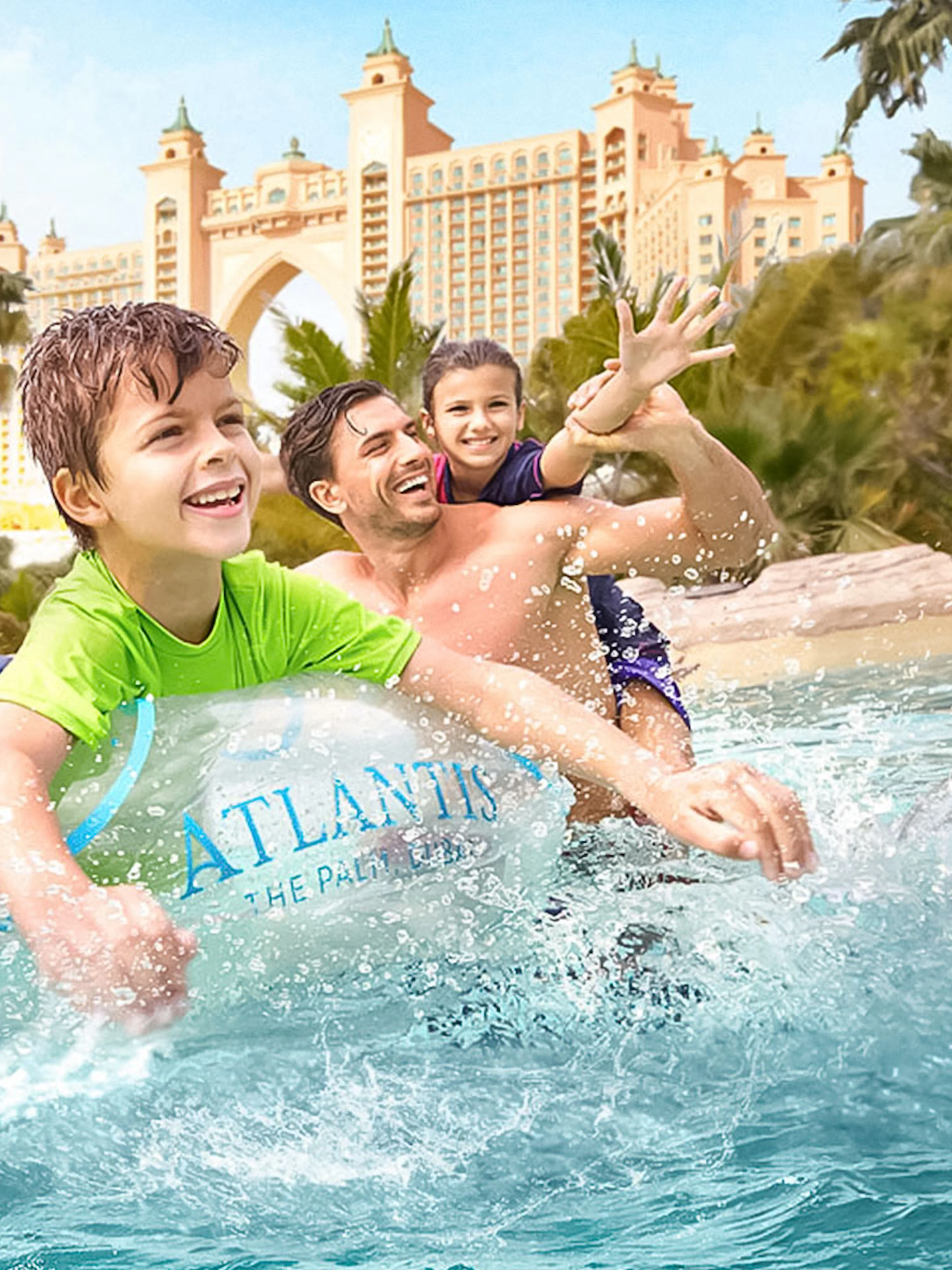 Family enjoying water ride at Atlantis The Palm with iconic hotel in background.