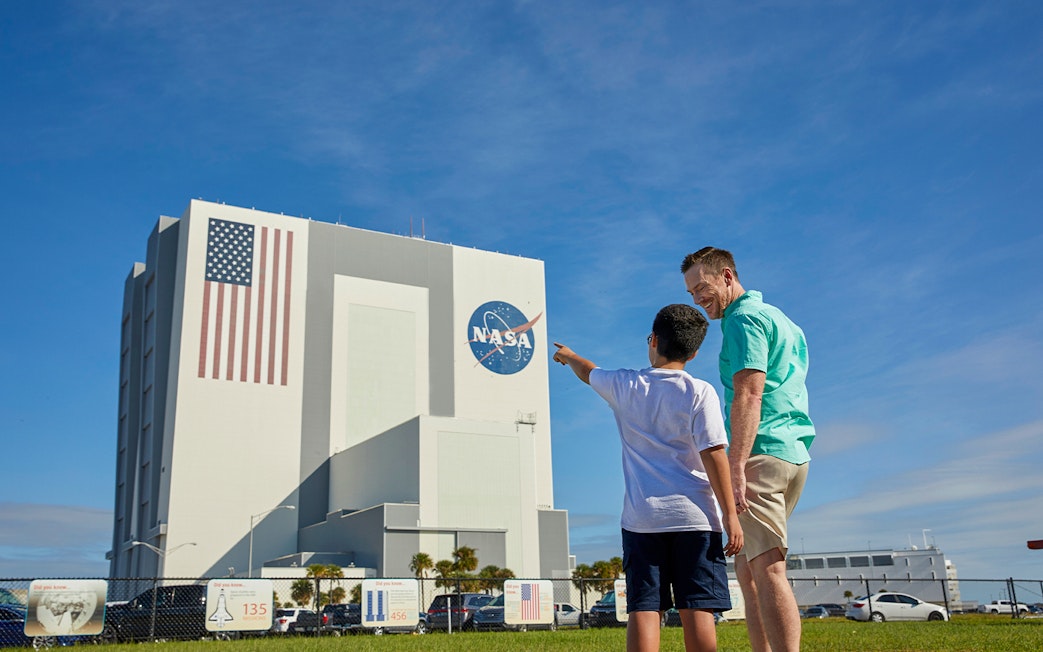 Father and son pointing at Vehicle Assembly Building, Kennedy Space Center.