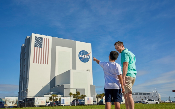 Father and son pointing at Vehicle Assembly Building, Kennedy Space Center.