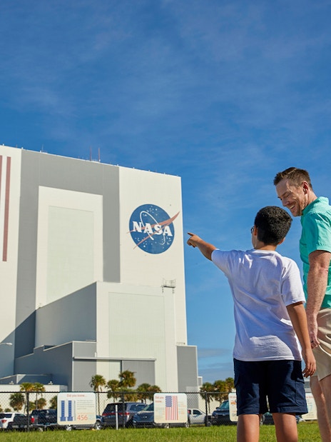 Father and son pointing at Vehicle Assembly Building, Kennedy Space Center.