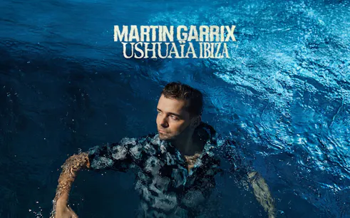 Person in water with 'Martin Garrix Ushuaïa Ibiza' text above, promoting Ibiza event.