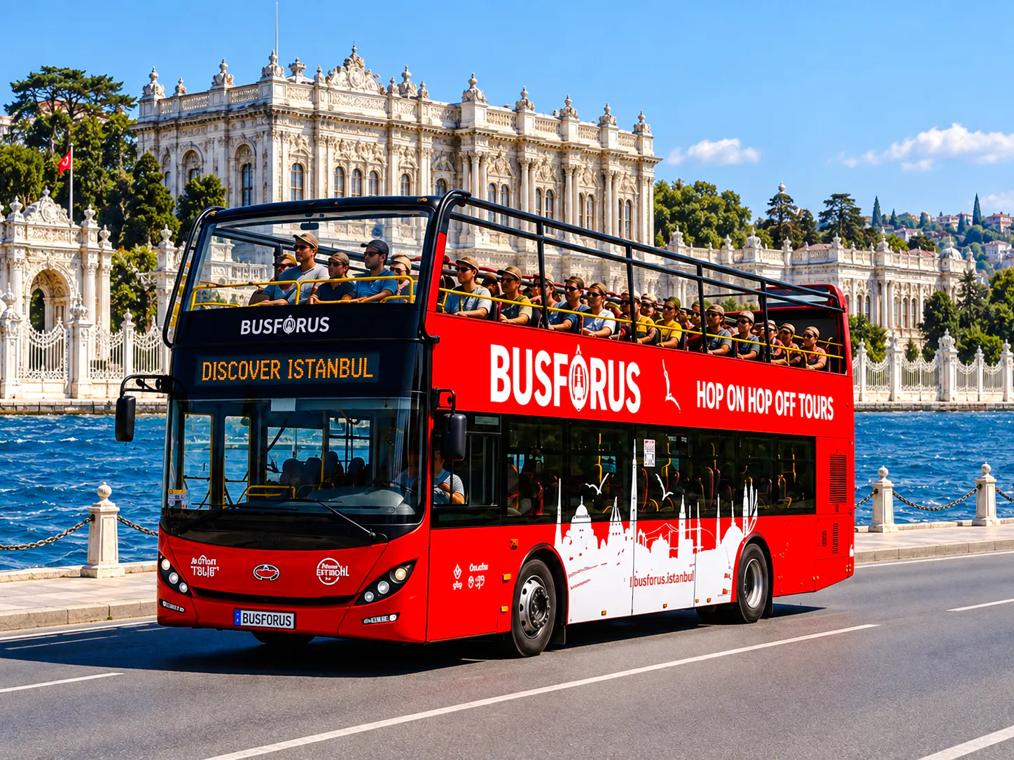 Open-top tour bus near Dolmabahçe Palace, Istanbul, with passengers enjoying the Bosphorus view.