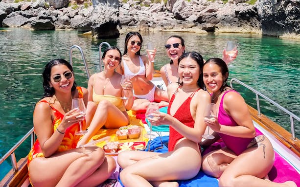 Group enjoying wine on a boat during a Taormina tour.