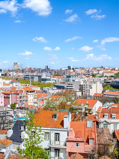 Lisbon cityscape with red rooftops and blue sky, view from Lisbon Hills.
