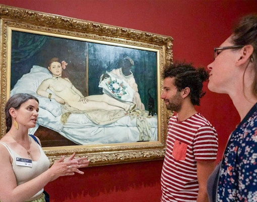 Guide explaining Manet's Olympia painting at Orsay Museum, Paris, France.