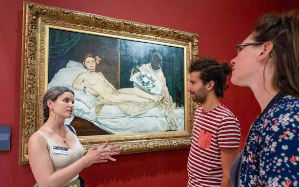 Guide explaining Manet's Olympia painting at Orsay Museum, Paris, France.