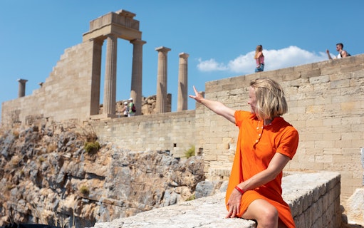 Person pointing at ancient ruins on the Acropolis in Athens, Greece.