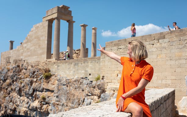 Person pointing at ancient ruins on the Acropolis in Athens, Greece.