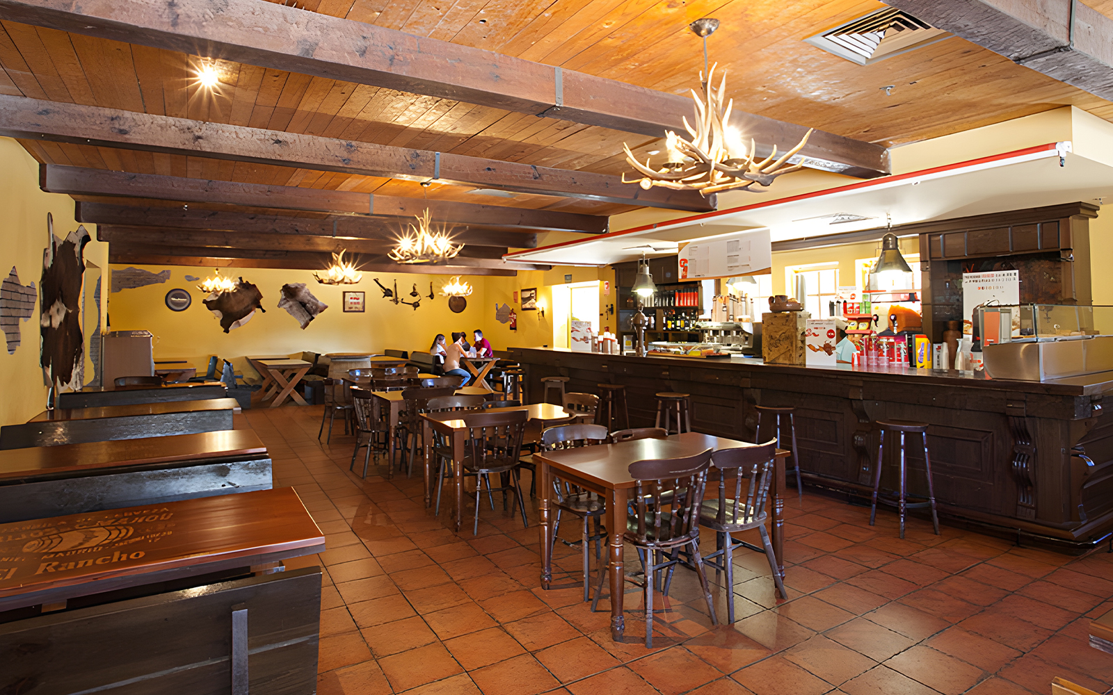 El Coyote Solitario Saloon interior at Parque Warner Madrid, featuring rustic decor and dining tables.