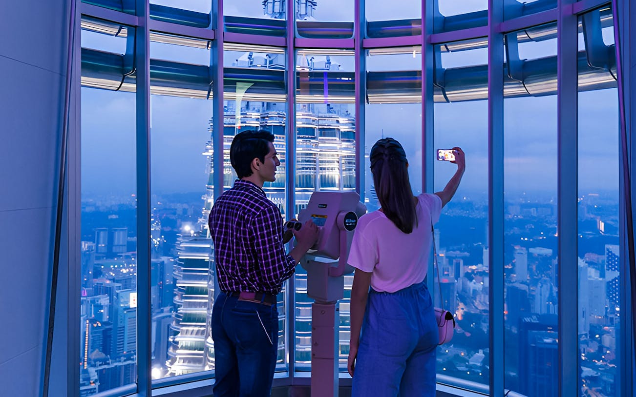 Petronas Twin Towers illuminated at night during a guided evening tour in Kuala Lumpur.
