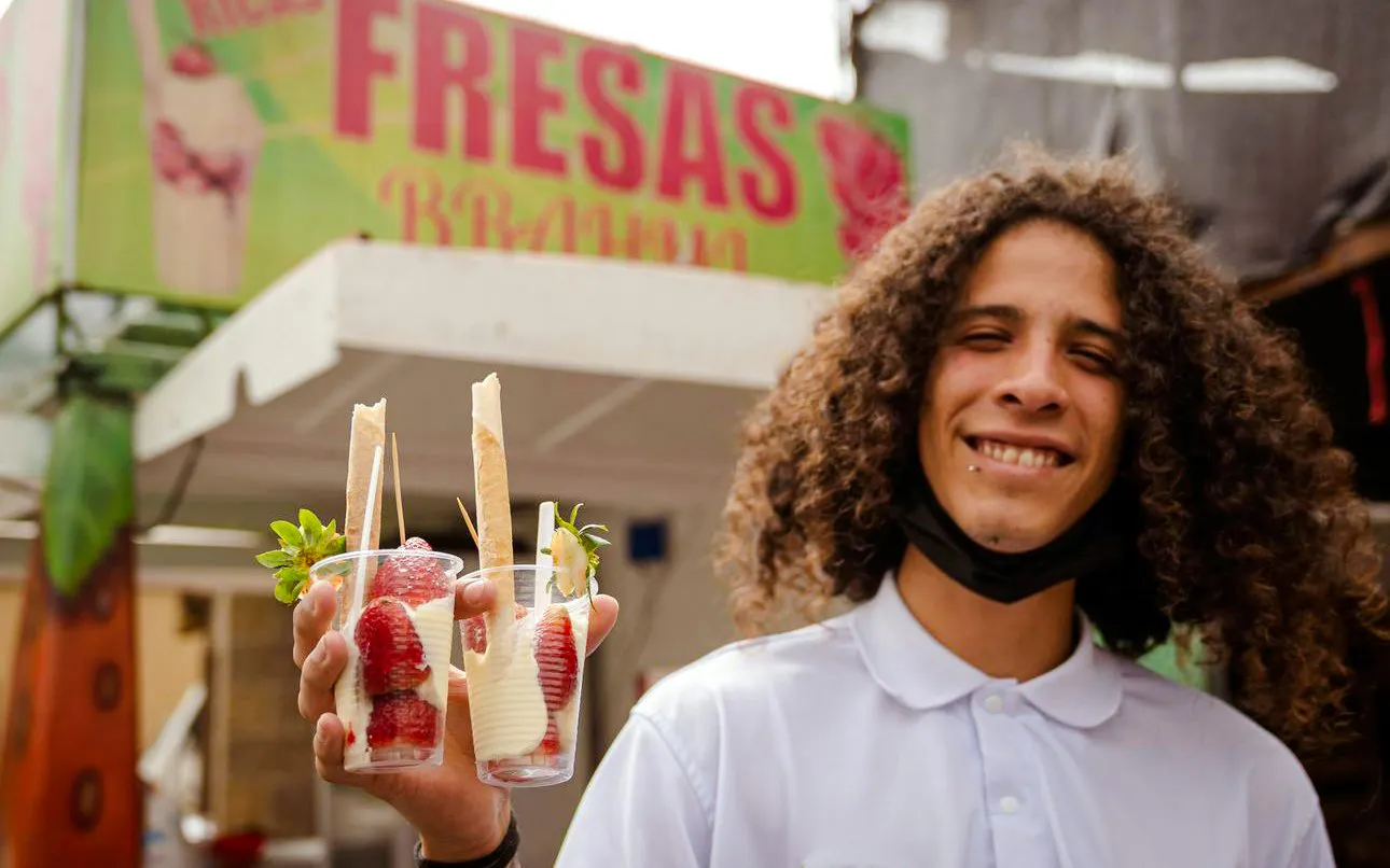 Guide holding strawberry desserts on Guatapé Gastronomic Tour.