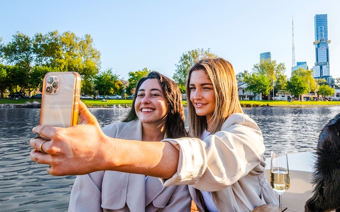 Women taking a selfie on a self-drive picnic cruise on Yarra River, Melbourne.