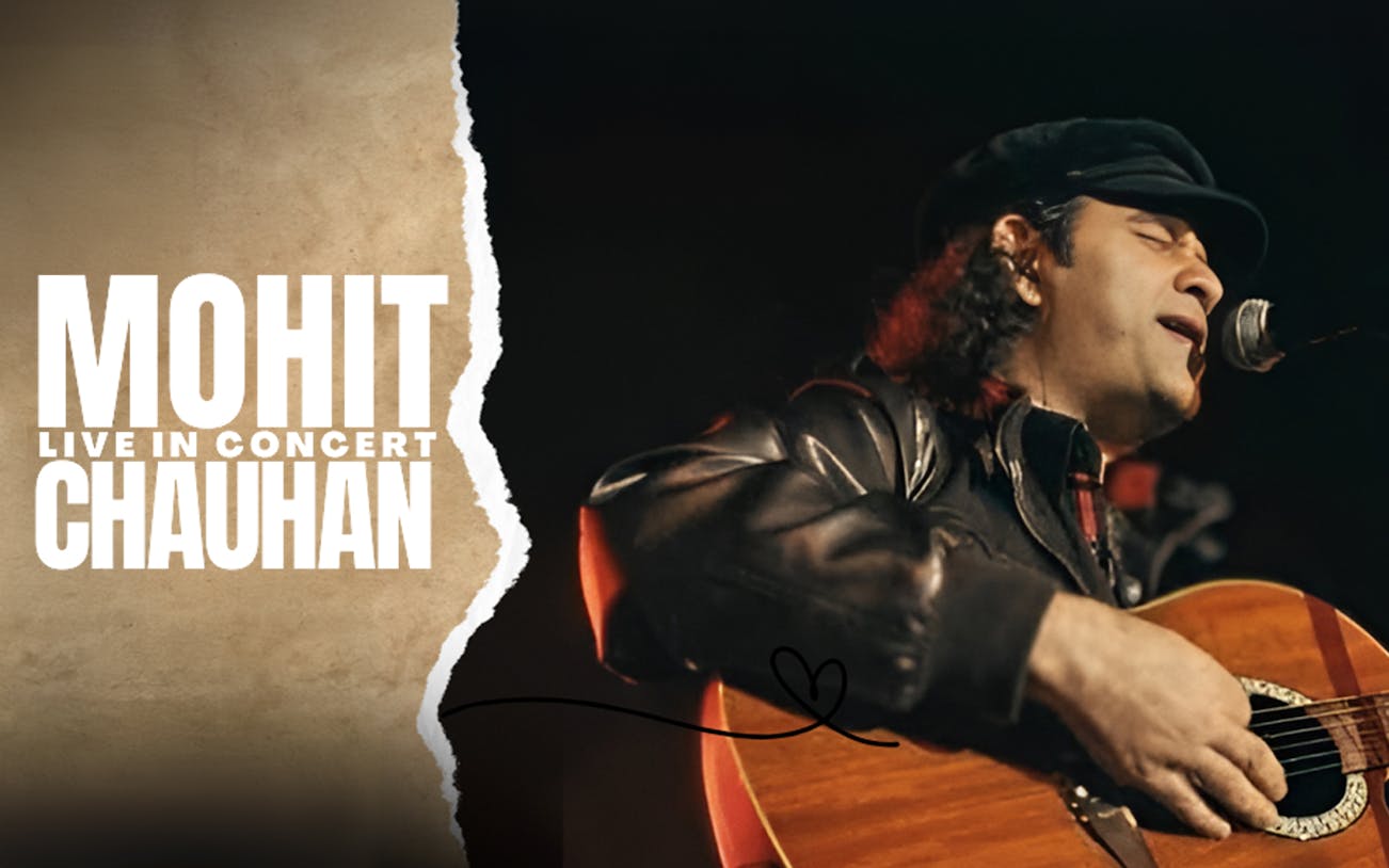 Mohit Chauhan performing live with a guitar at The Agenda concert venue.