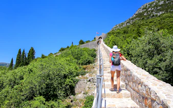 Woman walking on Ston town defensive wall, Peljesac Peninsula, Croatia.