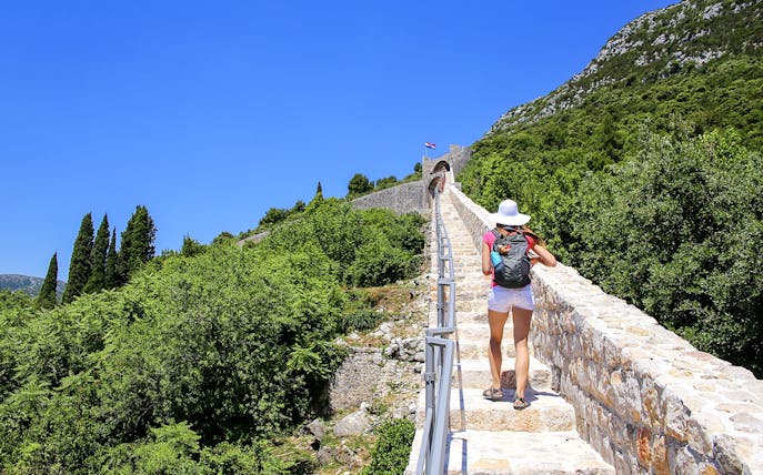 Woman walking on Ston town defensive wall, Peljesac Peninsula, Croatia.