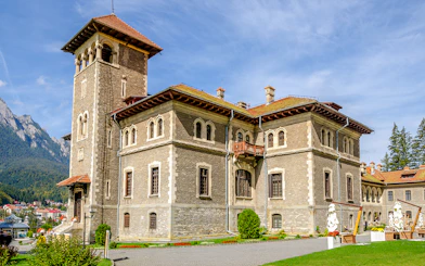 Cantacuzino Castle in Busteni Mountains with scenic backdrop.