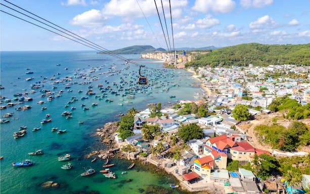 Aerial view of Phu Quoc island cable car ride over fishing boats and coastline, Vietnam.