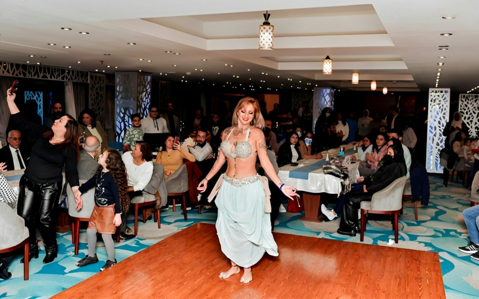 Belly dancer performing on a Nile River dinner cruise with guests watching.
