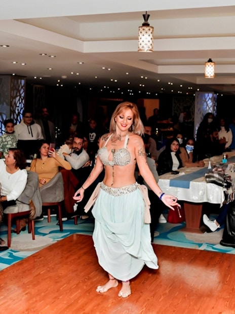 Belly dancer performing on a Nile River dinner cruise with guests watching.