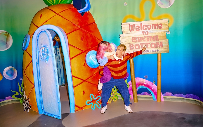 Visitors at SpongeBob Special, WONDR Experience, Amsterdam, near Bikini Bottom sign and pineapple house.