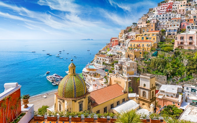 Positano village on the Amalfi Coast with colorful cliffside houses and boats on the sea.