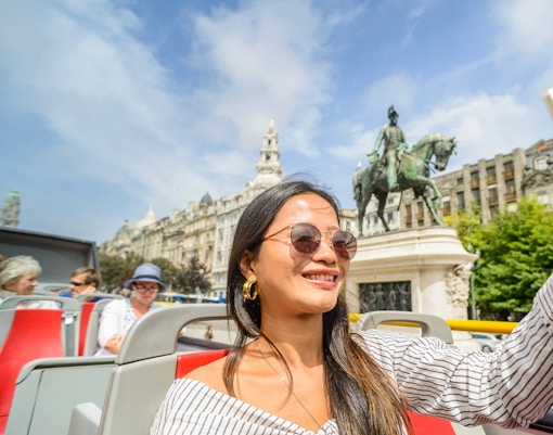 Touristes profitant d'une journée ensoleillée sur le City Sightseeing : Bus touristique Hop on Hop off Porto, passant par les sites emblématiques de Porto.