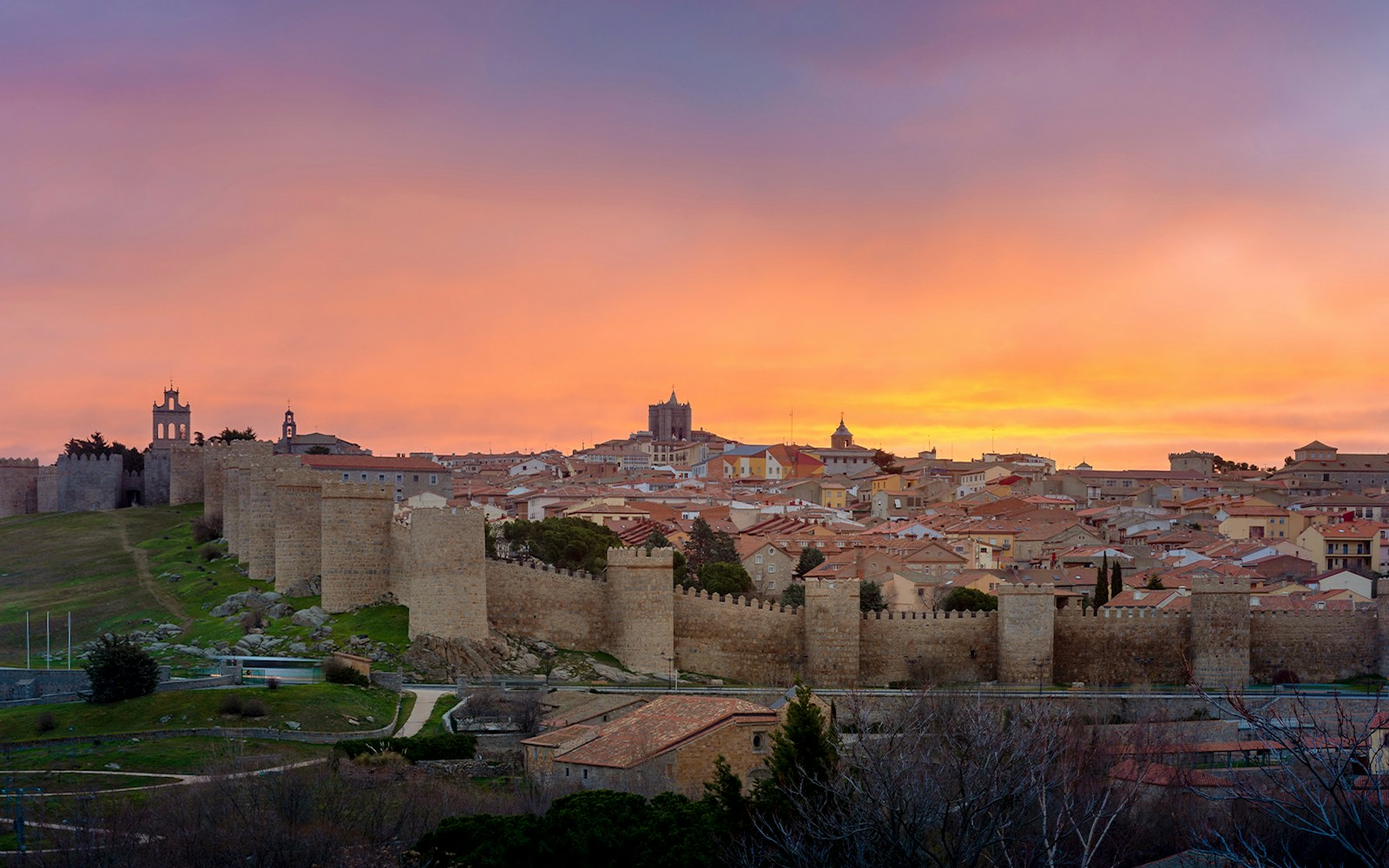 Panoramic view of Avila's medieval town walls at sunset from Los Cuatro Postes, Spain.