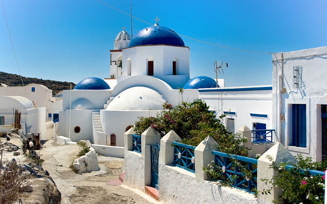 Thirassia village architecture with blue-domed church in Santorini.
