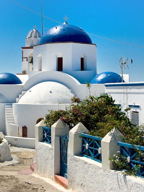 Thirassia village architecture with blue-domed church in Santorini.