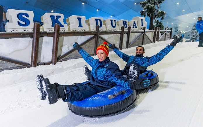 Visitors tubing at Ski Dubai indoor snow park, Dubai, UAE.