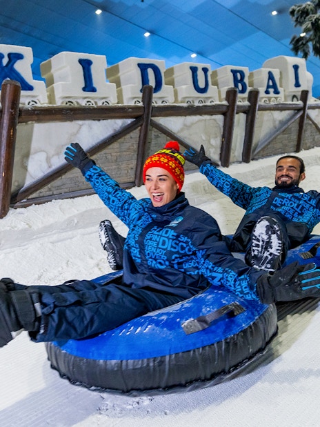Visitors tubing at Ski Dubai indoor snow park, Dubai, UAE.