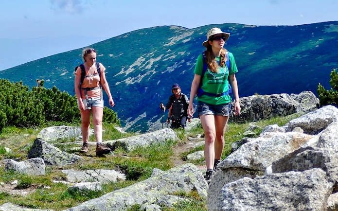 Hikers on a trail with mountain views during The Seven Rila Lakes tour from Sofia.