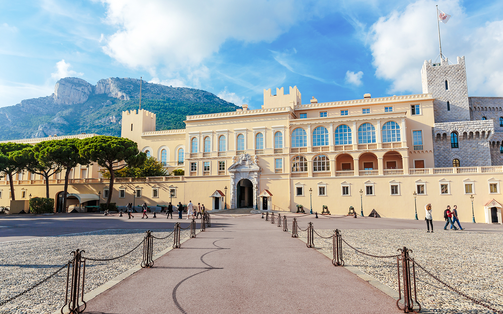Prince’s Palace in Monaco with tourists walking in the courtyard.