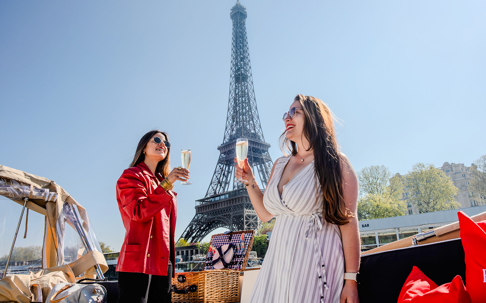 Ladies enjoying champagne on a Seine River cruise with the Eiffel Tower in the background.