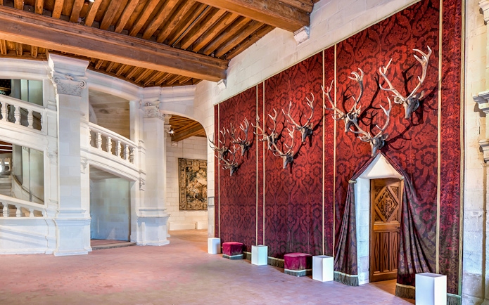 Chateau de Chambord interior with red tapestry and antler mounts.
