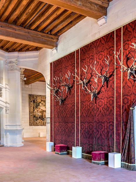 Chateau de Chambord interior with red tapestry and antler mounts.